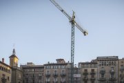 Una grua treballa en la construcció d'un edifici d'habitatges.