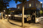 Fotografia de passatgers baixant d’un autobús a l’estació Reus Centre al vespre.