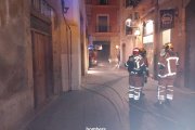 Els bombers treballant en l'incendi al local del carrer de la Nau.