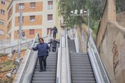 Usuaris de les escales mecàniques del carrer Vapor, baixant els graons a peu.