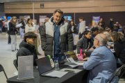 Fotografia d’un expositor de la Jornada Treballa al Turisme atenent a un visitant.