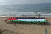 Imatge de la bandera de Palestina desplegada a la platja del Miracle aquest dissabte
