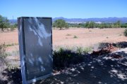 Caixa de connexions elèctriques al costat d'un terreny buit del polígon industrial del Molló