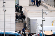 Un operari, protegit per un gran nombre d'agents de la Guàrdia Civil, carregant una de les obres al camió.