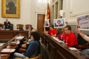 Regidors de la CUP aixecant fotografies de dirigents del Partit Popular, ahir en el ple municipal.