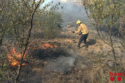 Un bomber apagant l'incendi, declarat a primera hora de la tarda.