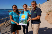 Les copropietàries de l'empresa organitzadora, Plàncton Diving, i l'alcalde de l'Ametlla de Mar, amb el cartell de l'esdeveniment.