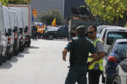 Agents de la Guàrdia Civil, amb manifestants al fons, a la nau de Bigues i Riells on han trobat paperetes de l'1-O. Imatge del 20 de setembre del 2017