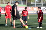 A la imatge, en Carlos Rovira ajuda als jugadors del Nàstic Genuine en allò que necessiten. Els entrenaments es realitzen tots els dilluns a l'annex de gespa artificial del Nou Estadi.