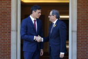 El president de la Generalitat, Quim Torra, i el president del govern espanyol, Pedro Sánchez, encaixen les mans a les portes del palau de la Moncloa.