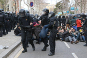 Un grup d'antiavalots dels Mossos d'Esquadra desallotgen una dona concentrada davant del TSJC.