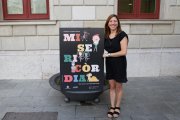 Laia Arriols, dissenyadora del cartell de les Festes de Misericòrdia 2018, junt a la seva creació.