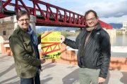 El president d'Amics i Amigues de l'Ebre, Marc March, i el responsable de l'empresa Terra Enllà, Andreu Caralt, davant del Pont Roig de Tortosa on tindrà lloc l'acte del 15 d'abril.