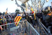 Manifestants davant agents dels Mossos d'Esquadra que controlen els accessos a l'edifici del Parlament.