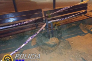 Imatge dels dos bancs, mig arrancats i precintats amb cinta policial.