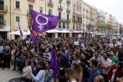 Pla general de les persones concentrades a la plaça de la Font de Tarragona en rebuig a la sentència de 'La Manada', amb una bandera feminista sobresortint d'entre la multitud. Imatge del 26 d'abril del 2018