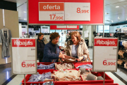 Dues dones miren llenceria de roba en uns grans magatzems de la ciutat.