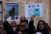 Dos manifestants alçant cartells reivindicatius en la protesta per la mort d'un rottweiler abatut per la Policia Local de Calafell.