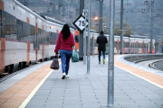 Dos passatgers del tren de la línia R4 de Manresa. Al fons, el tren.