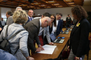 El senador electe d'ERC Raül Romeva signant un document durant el tràmit de recollida de l'acta de senador acompanyat d'altres senadors republicans.