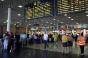 Pla general de cues per facturar a l'Aeroport de Reus i del panell informatiu que indica retards en els vols amb destinació al Regne Unit que operava la companyia Thomas Cook. Imatge del 24 de setembre del 2019. (Horitzontal) Vincular  Crear