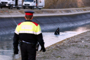 Un mosso caminant pel voral del canal de Seròs i la unitat subaquàtica dins el canal, on s'ha trobat el cotxe de la veïna de les Borges Blanques.