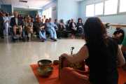 Un dels membres del duet IOMA d'esquenes i els usuaris al fons durant l'acció sonora feta a l'hospital Verge de la Cinta de Tortosa.