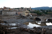 Pla general de dos bombers damunt del pont Vell de Montblanc i d'una excavadora fent tasques de neteja. Imatge del 26 d'octubre del 2019 (Horitzontal).