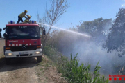 Un bomber amb la mànega treballant a l'incendi.