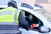 Pla mitjà d'un agent de la policia local de Sant Carles de la Ràpita demanant la documentació a un conductor en el control d'accés al nucli urbà.