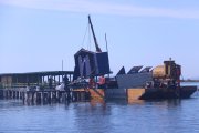 Una grua aixecant la caseta dels lavabos del Xiringuito de la Costa, a la Punta de la Banya.