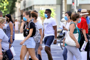 Diverses persones amb mascaretes en un pas de vianants.