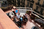 El grupo Stay Homas saludando mientras tocan en la terraza del piso que comparten en el Eixample de Barcelona.