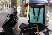 Una motocicleta de repartiment de menjar a domicili que fa el servei per a Deliveroo.