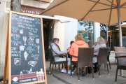 Un grup de persones consumint en una terrassa a Girona.