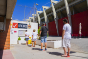 Quatre persones fan cua fora de les oficines de la Budellera esperant a recollir el seu carnet.