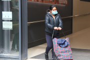 Plano cerrado de una cliente que lleva mascarilla saliendo de un supermercado en Barcelona.