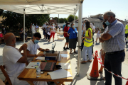 Cua de persones a Alcarràs per anar-se a fer la prova PCR.