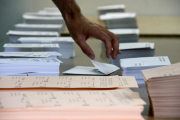 Una mano en medio de boletos en el Congreso y el Senado en las elecciones del 26-J.