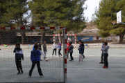 Nens jugant a futbol durant l'hora d'esbarjo al pati de l'escola.