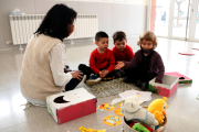 Tres alumnos de P-3 escuchando las explicaciones de la maestra.