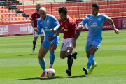 Dos jugadors de l'Ibiza perseguint a un del Nàstic.