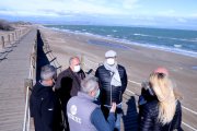 Pla general d'un grup de veïns de Riumar a la zona nord de la platja, on el mar s'aproxima a les passarel·les de fusta.