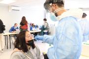 Plano medio de una estudiante universitaria en un cribado masivo.