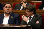 El presidente de la Generalitat, Carles Puigdemont, habla con el vicepresidente, Oriol Junqueras, en el Parlamento, el 26 de octubre del 2017