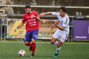 Un jugador del Olot con el esférico perseguido por un jugador del Nàstic.