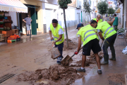 Un grup de voluntaris de l'Ametlla de Mar treballant en les tasques de neteja d'un dels carrers principals de les Cases d'Alcanar.