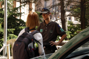 Una agente de los Agentes Rurales explica a una turista que no puede acceder por el Camino de Sant Miquel.