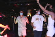 Un grup de joves amb mascareta balla a l'interior d'una una discoteca.