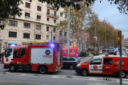 Pla general del dispositiu de Bombers a les portes de l'immoble incendiat.